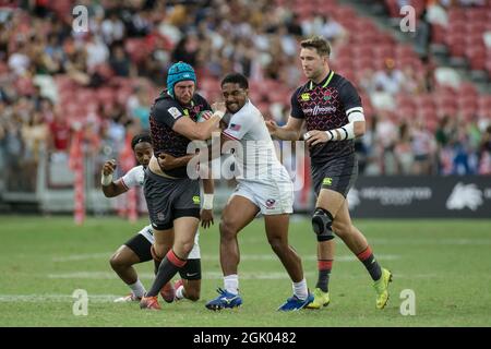 SINGAPOUR-AVRIL 14:l'équipe d'Angleterre 7s (bleue) joue contre l'équipe d'USA 7s (blanche) lors du match de médaille de bronze de HSBC World Rugby Singapore Sevens le 14 avril 2019 au Stade national de Singapour Banque D'Images