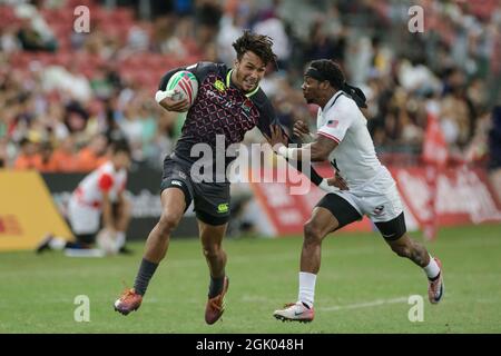 SINGAPOUR-AVRIL 14 : Ryan Olofofela de l'équipe d'Angleterre 7s (bleu) en action contre l'équipe de Carlin Isles des États-Unis 7s (blanc) lors du match de médaille de bronze de HSBC World Rugby Singapore Sevens le 14 avril 2019 au Stade national de Singapour Banque D'Images