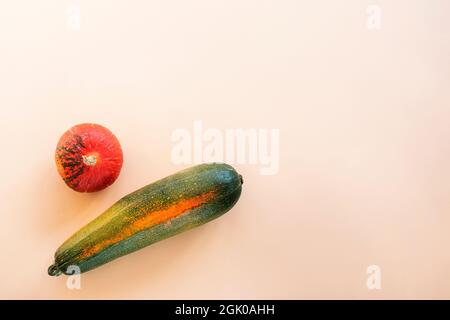 Courgettes et citrouilles sur fond beige. Concept de récolte d'automne. Vue de dessus, plat, espace de copie. Banque D'Images