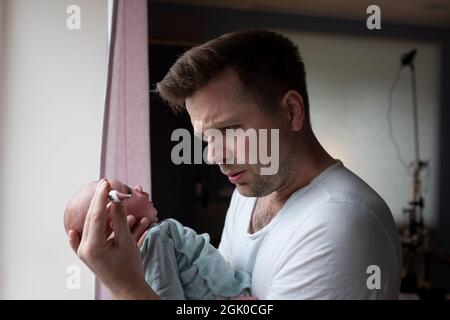 J'avais peur de voir un père qui cherche un thermomètre pour tenir son nouveau-né entre les mains. Banque D'Images