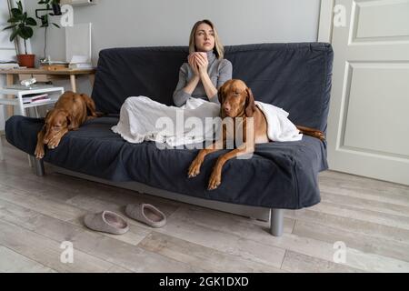 Femme indifférente lutte avec la dépression bipolaire et le trouble mental rester à la maison avec deux chiens Banque D'Images