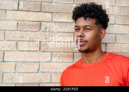 Portrait du jeune afro latin contre un mur de briques Banque D'Images