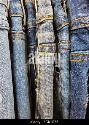 Rangée de nouveaux jeans bleus accrochés au porte-vêtements du magasin Banque D'Images