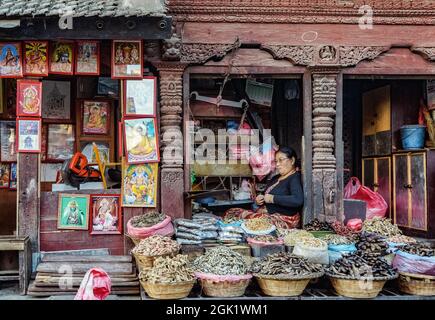 Femme népalaise d'âge moyen qui vend des épices dans une épicerie traditionnelle du marché de Katmandou, à côté de la place Durbar Banque D'Images