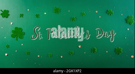 Concept de décoration « Happy St. Patrick Day ». Pose à plat, vue de dessus des feuilles de trèfle sur fond vert Banque D'Images