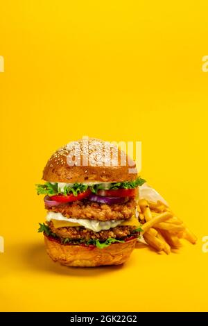 Gros double-hamburger avec escalope de poulet pané et frites Banque D'Images