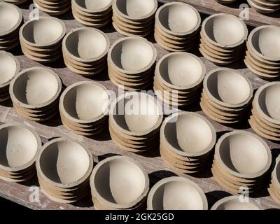 Beaucoup de petites assiettes, forme ronde faite d'argile céramique et séchées au soleil. Fabrication de la faïence. Banque D'Images