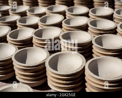 Beaucoup de petites assiettes, forme ronde faite d'argile céramique et séchées au soleil. Fabrication de la faïence. Banque D'Images