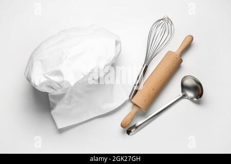 Chapeau de chef et ustensiles de cuisine sur fond blanc Banque D'Images