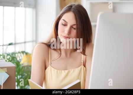 Femme propriétaire d'entreprise traitant la commande dans un magasin d'entrepôt Banque D'Images