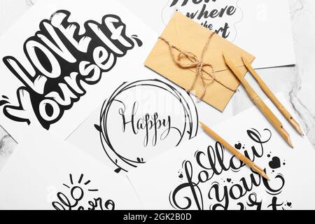 Trempez les stylos et les enveloppes sur des feuilles de papier avec différents textes Banque D'Images