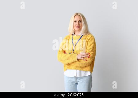 Portrait d'une femme mûre avec badge sur fond gris Banque D'Images