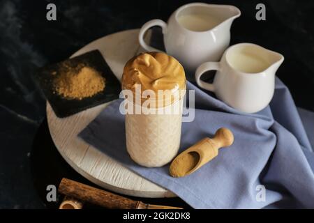 Verre de délicieux dalgona hojicha latte sur fond sombre Banque D'Images