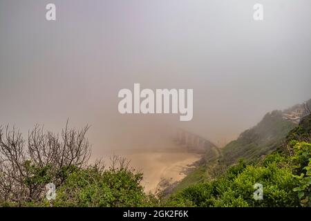 Vue sur la plage de Kaaiman's River Beach avec pont ferroviaire pendant la matinée brumeux à Wilderness dans la route des jardins de Western Cape, Afrique du Sud. Banque D'Images
