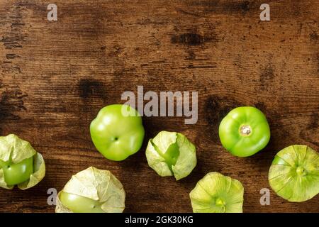 Tomatillos, tomates vertes, Top shot avec espace de copie. Ingrédients mexicains sur fond de bois rustique sombre Banque D'Images