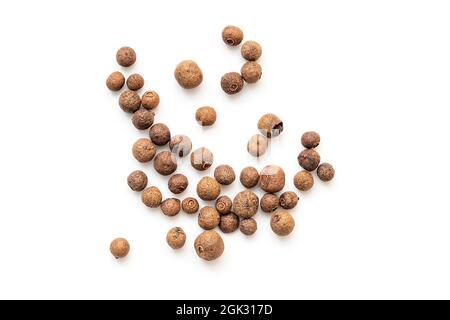 Allépice, grains d'allépice ou poivre noir isolés sur blanc. Poivre dispersé, vue du dessus Banque D'Images
