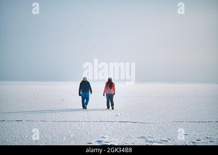 Un gars et une fille marchent sur un lac gelé, sur la glace, en hiver Banque D'Images