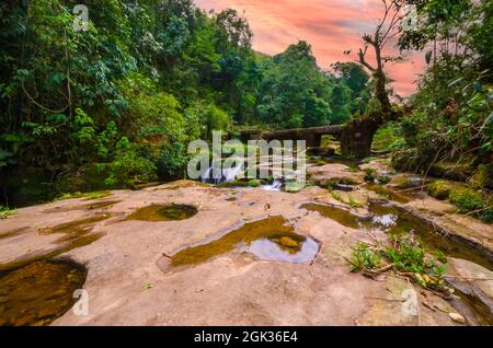 Un pont en pierre au-dessus d'un ruisseau de montagne sur le chemin des cascades de Krang Shuri ou Krang Suri près du village d'Amlaren dans les collines de Jaintia, Meghalaya, Inde. Banque D'Images