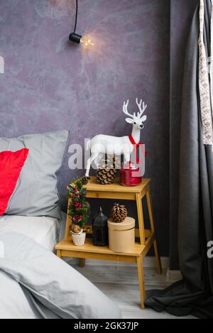 Décoration de Noël dans la chambre. Cerf blanc avec foulard rouge et cônes Banque D'Images