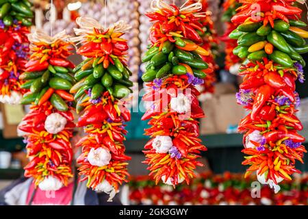 Chillis frais, rouge et vert, coloré, poivrons au Chili, clous de girofle à l'ail et à l'ail, en vente sur un marché Banque D'Images