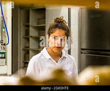 Naomi Antognini, fille d'Arno Antognini, regarde intensément la boulangerie Pasticceria Marnin à Locarno. Via Valmarella, Tessin, Suisse. Banque D'Images