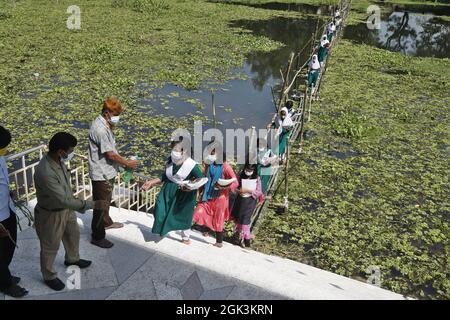 Les élèves venant de l'école marchant sur le pont Bamboo comme la zone scolaire touchée par l'eau d'inondation plusieurs mois, toutes les écoles et les collèges dans le pays commencent à rouvrir. Le 12 septembre 2021 à Gazipur City, Bangladesh. Photo de Harun-or-Rashid/Eyepix Group/ABACAPRESS.COM Banque D'Images