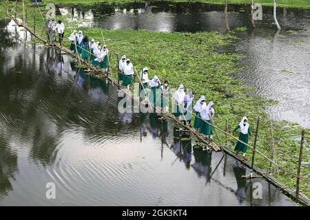 Les élèves venant de l'école marchant sur le pont Bamboo comme la zone scolaire touchée par l'eau d'inondation plusieurs mois, toutes les écoles et les collèges dans le pays commencent à rouvrir. Le 12 septembre 2021 à Gazipur City, Bangladesh. Photo de Harun-or-Rashid/Eyepix Group/ABACAPRESS.COM Banque D'Images