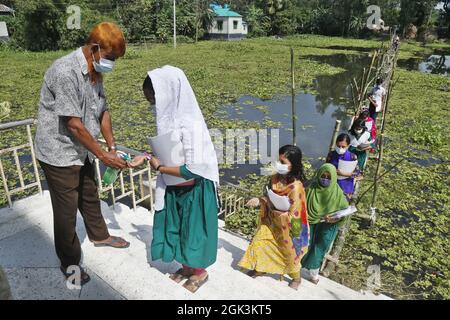 Les élèves venant de l'école marchant sur le pont Bamboo comme la zone scolaire touchée par l'eau d'inondation plusieurs mois, toutes les écoles et les collèges dans le pays commencent à rouvrir. Le 12 septembre 2021 à Gazipur City, Bangladesh. Photo de Harun-or-Rashid/Eyepix Group/ABACAPRESS.COM Banque D'Images