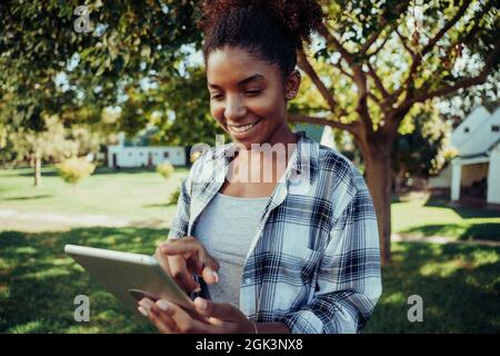 Race mixte dactylographie féminine sur tablette numérique étudier pour le test en plein air Banque D'Images