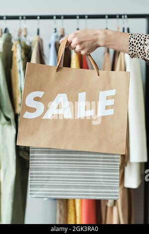 Gros plan du client tenant des sacs de papier pendant qu'il fait ses achats dans le centre commercial pendant la vente Banque D'Images