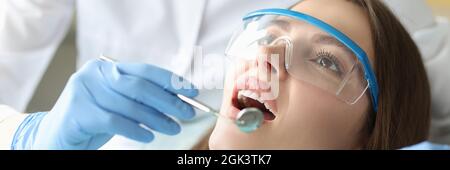 Le dentiste examine la cavité buccale de la femme dans le bureau de près Banque D'Images