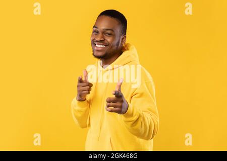 Heureux Africain homme pointant les doigts vers l'appareil photo sur fond jaune Banque D'Images