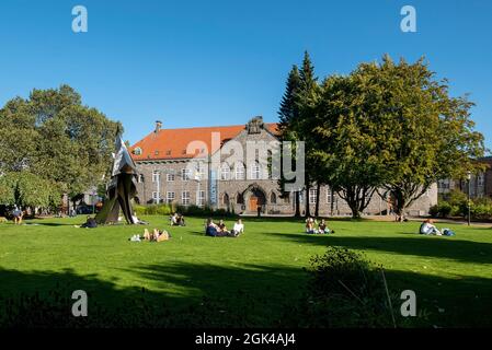 Les gens qui profitent d'une journée ensoleillée d'été dans le parc en face de la bibliothèque publique de Bergen Offentlige Bibliotek (Hovedbiblioteket) à Bergen, en Norvège Banque D'Images