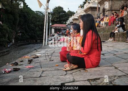 Femmes effectuant des rituels au temple de Pashupatinath, Katmandou, au festival de Teej Banque D'Images