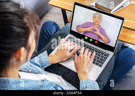 Une femme ou une mère heureuse qui fait un appel vidéo avec une jeune fille adulte Banque D'Images