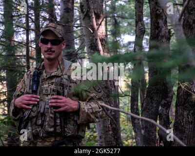 Sergent d'état-major de l'armée américaine Wyatt Brown, 2-211th Army Regiment, se dresse dans une zone boisée dans une simulation de mission de recherche et de sauvetage au combat pendant la grève du Nord (NS) 21-2 près d'Ontonagon (Michigan), le 3 août 2021. NS optimise la préparation au combat en offrant une formation flexible et rentable allant des compétences tactiques individualisées aux environnements de menace contestée par les pairs et d'armes combinées axés sur l'intégration des forces communes et de coalition et la convergence des domaines. Banque D'Images