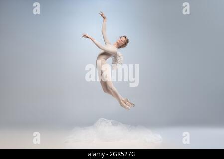 Danseuse de ballet jeune et gracieuse, danseuse de ballerine à l'image d'ange avec des ailes isolées sur fond gris de studio. Art, mouvement, action, flexibilité Banque D'Images