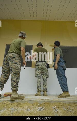 (Photo de gauche à droite) 2e lieutenant du corps des Marines des États-Unis, Robert Rogers, officier responsable du programme d'action civique en génie, Sgt. Jacob Sperr et Cpl. Jaime Delgado, ingénieurs de combat, affecté à Bridge Company, 9e Bataillon de soutien technique, 3d Marine Logistics Group, peint l'extérieur de l'école Baan Mai Thai Pattana pendant l'exercice Cobra Gold, dans la province de sa Kaeo, Royaume de Thaïlande, 3 août 2021. Les Marines des États-Unis se sont joints aux Forces armées royales thaïlandaises pour construire une installation polyvalente de 8 x 20 mètres qui aidera à accueillir le nombre croissant d’élèves de l’école, et permettra une unité d’information éducative Banque D'Images