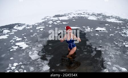 Vue en grand angle de la femme active senior en maillot de bain extérieur en hiver, concept de thérapie froide. Banque D'Images