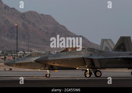 Deux F-22 Raptors affectés à la 1re Escadre Fighter, base aérienne de Langley (Virginie), se présentent avant le décollage pour une mission d'entraînement de nuit pendant le Red Flag-Nellis 21-3 à la base aérienne de Nellis (Nevada), le 4 août 2021. Le 1er FW a accueilli RF-Nellis 21-3 comme aile principale avec près de 100 avions, comme le F-35, F-35, F-22, F-16CJ, F-16C, EC-130H, EA-18G, B-52, B-2, F/A-18 C/D, MQ-9, E-3, E-8, RC-135, RQ-4B30, RQ-4B40, U-2, HH-60, HC-130, KC-135 ET KC-46, cela a participé à des scénarios de mission complexes contre les forces d'agresseur. Banque D'Images