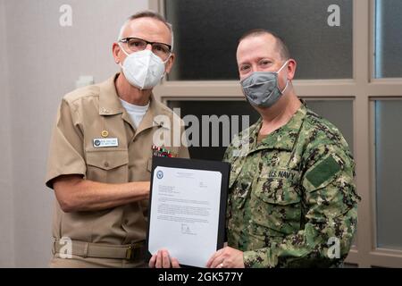 Musicien de 1re classe David Aspinwall, de Roswell, en Géorgie, reçoit une lettre d'appréciation du capitaine Kenneth Collins, commandant de la U.S. Navy Band, à l'occasion de sa retraite après 22 ans de service naval. Banque D'Images