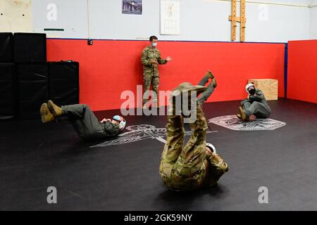 Les membres de l'équipage des 41e et 61e escadrons de transport aérien pratiquent l'atterrissage en parachute sous la direction du sergent d'état-major. Joshua Tucker, instructeur du 19e Escadron de soutien aux opérations, Survival, Evasion, Resistance and Escape (SERE), lors d'un cours de préparation du SERE à la base aérienne de Little Rock, Arkansas, le 5 août 2021. Les membres de l'équipage ont reçu des instructions sur les procédures de parachutisme d'urgence. Banque D'Images