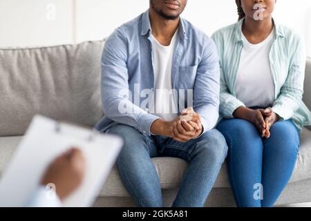 Vue rognée d'un jeune couple noir marié en consultation avec un psychologue, en cours de thérapie familiale à la clinique Banque D'Images