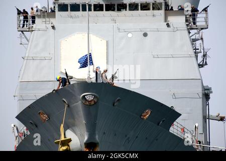 PORT DE DJIBOUTI, Djibouti (6 août 2021) les marins de la marine américaine du croiseur à missiles guidés USS Monterey (CG 61) abaissent le cric naval avant de quitter le port de Djibouti pour commencer, le 6 août 2021. Camp Lemonnier, Djibouti (CLdJ) sert de base expéditionnaire pour les forces militaires américaines fournissant un soutien aux navires, aéronefs et personnel qui assurent la sécurité dans toute l'Europe, l'Afrique et l'Asie du Sud-Ouest. La CLdJ permet des opérations maritimes et de combat dans la Corne de l'Afrique tout en favorisant des relations positives entre les États-Unis et l'Afrique. La base abrite également la Force opérationnelle conjointe de la Corne de l'Afrique, avec Banque D'Images