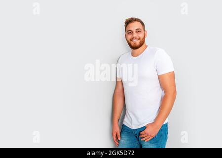 Gros plan de jeune barbu rouge posant, isolé sur fond blanc. Concept de modèle de mode. Photo de haute qualité Banque D'Images