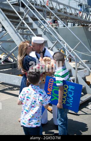 NORFOLK, Virginie (août 6, 2021) - Un Sailor embrasse sa femme après son retour du déploiement à bord du destroyer à missiles guidés de la classe Arleigh Burke USS Mahan (DDG 72) à la base navale de Norfolk août 6. Mahan, un navire du Eisenhower Carrier Strike Group (IKE CSG), est retourné à homeport à la station navale de Norfolk en août 6, après un déploiement de six mois dans les zones d'exploitation de la 5e et de la 6e flotte américaine. Banque D'Images