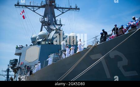 NORFOLK, Virginie (août 6, 2021) - les marins à bord du destroyer de missiles guidés de classe Arleigh Burke USS Mahan (DDG 72) déferle devant la foule de familles à la base navale de Norfolk août 6. Mahan, un navire du Eisenhower Carrier Strike Group (IKE CSG), est retourné à homeport à la station navale de Norfolk en août 6, après un déploiement de six mois dans les zones d'exploitation de la 5e et de la 6e flotte américaine. Banque D'Images