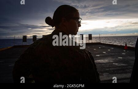 Le 1er lieutenant Elizabeth Schilder, officier de contrôle du matériel au 31e corps expéditionnaire maritime (UMM), attend des instructions supplémentaires lors d'une compétition de tir à bord du navire d'assaut amphibie USS America (LHA 6) dans la mer Salomon, le 7 août 2021. L'événement a consisté en des marins et des Marines en compétition pendant qu'ils shoot une série d'exercices avec un but d'avoir le score total le plus élevé. Le 31e MEU opère à bord des navires du groupe de grève expéditionnaire américain dans la zone d'opération de la 7e flotte afin d'améliorer l'interopérabilité avec les alliés et les partenaires et de servir de force de réaction prête à l'emploi Banque D'Images