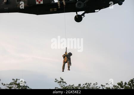 Un paramédic de vol de l'armée américaine avec le chef de la Force opérationnelle Diamond, 25th Aviation Regiment, est hissé sur un penetrator Jungle, un outil utilisé pour extraire les victimes ambulatoires des zones fortement boisées, à la zone d'entraînement Baturaja, en Indonésie, le 9 août 2021. Garuda Shield 21 est un exercice conjoint de deux semaines entre l'armée américaine et les forces armées indonésiennes de Tentara (TNI-AD Indonesia Army Forces). Le but de cet exercice conjoint est d'améliorer et d'enrichir la capacité de guerre dans la jungle de l'armée américaine et de l'armée indonésienne. Banque D'Images