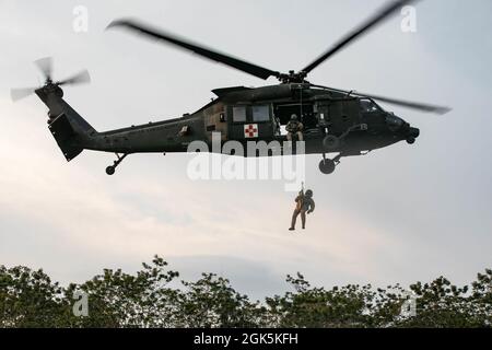 Un paramédic de vol de l'armée américaine avec le chef de la Force opérationnelle Diamond, 25th Aviation Regiment, est hissé sur un penetrator Jungle, un outil utilisé pour extraire les victimes ambulatoires des zones fortement boisées, à la zone d'entraînement Baturaja, en Indonésie, le 9 août 2021. Garuda Shield 21 est un exercice conjoint de deux semaines entre l'armée américaine et les forces armées indonésiennes de Tentara (TNI-AD Indonesia Army Forces). Le but de cet exercice conjoint est d'améliorer et d'enrichir la capacité de guerre dans la jungle de l'armée américaine et de l'armée indonésienne. Banque D'Images